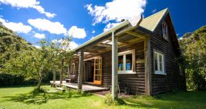 a small wooden house with a porch and grass at The Innlet, Country Apartments and Cottages in Collingwood