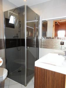 y baño con ducha y lavamanos. en Domki u Skrzata Drewniane, en Łeba