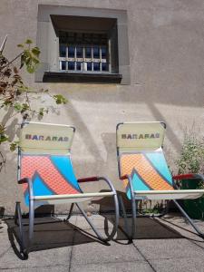 deux chaises assises devant un bâtiment dans l'établissement Barabas Luzern, à Lucerne