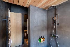 a bathroom with a shower with bottles on a wall at Foxwood D in Niseko +64 photos