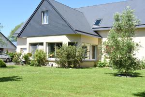 une maison avec un toit noir et une cour dans l'établissement Mon Saint Michel, à Ardevon