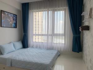 um quarto com uma cama em frente a uma janela em MRT Apartment In Masteri Thao Dien em Ho Chi Minh