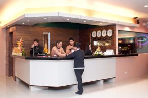 a man standing at a bar in a restaurant at Allure Hotel & Suites in Cebu City