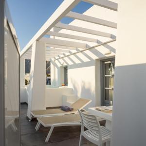 a patio with white furniture and a table and chairs at Antoperla Luxury Hotel & Spa in Perissa