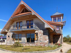 una casa de madera con una torre encima de ella en Āķagals, en Pāvilosta