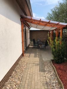un patio avec une table et des chaises sous une pergola dans l'établissement Ferienwohnung mit Blick auf die Burg Stargard, à Burg Stargard