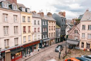 una calle en una ciudad con edificios y coches en Chambre Roméo ou Juliette, en Honfleur 10 fotos más