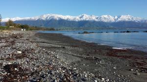 
a large body of water with mountains at The Anchor Inn Beachfront Motel in Kaikoura
