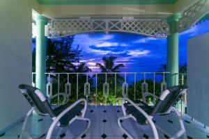 a balcony with two chairs and a view of the ocean at Palm Beach Hotel in Grand'Anse Praslin