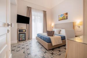 Habitación de hotel con cama y TV en Maison Marie, en Sorrento