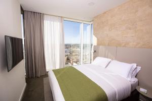 a bedroom with a large bed with a large window at Holiday Inn Algiers - Cheraga Tower, an IHG Hotel in Alger