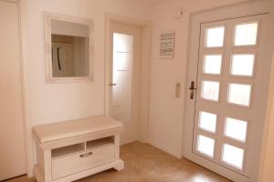 a white room with a door and a mirror at Ferienhaus Förster II in Friedrichsbrunn