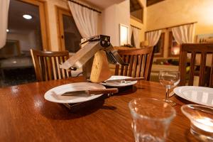 a wooden table with a knife and plates on it at Parc Madeleine - APARTMENTS in Saint-François-Longchamp