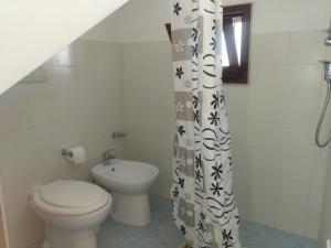 ein Bad mit einem WC und einem Duschvorhang in der Unterkunft Orchidea in Sant'Isidoro
