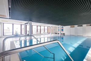 une piscine à l'eau bleue dans un immeuble dans l'établissement Terrassenpark Apartments (Premium Rooms), à Sasbachwalden