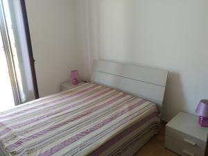 ein kleines Schlafzimmer mit einem Bett und einem Fenster in der Unterkunft Orchidea in Sant'Isidoro