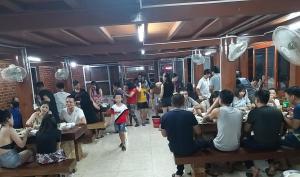 a group of people sitting at tables in a restaurant at Eco House Mộc Châu in Mộc Châu +96 photos