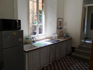 a kitchen with a counter with a sink and a window at Bed & Breakfast Dèco in Torno