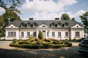 a large white house with a garden in front of it at Hotel&SPA Dwór Droblin in Leśna Podlaska