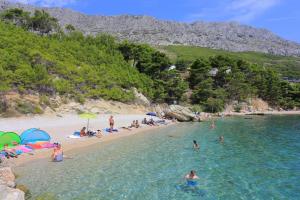 a group of people on a beach in the water at Triple Room Lokva Rogoznica 2973g in Lokva Rogoznica