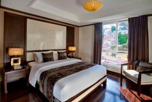 a bedroom with a large bed and a large window at Golden Lotus Luxury Hotel in Hanoi
