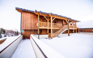 uma cabana de madeira na neve em Parc Madeleine - APARTMENTS em Saint-François-Longchamp