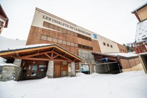 um edifício com um sinal na neve em Parc Madeleine - APARTMENTS em Saint-François-Longchamp