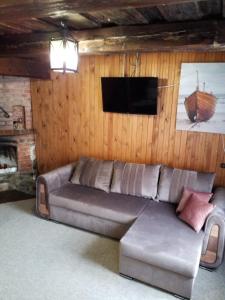 sala de estar con sofá y TV de pantalla plana en "MARKIZAS" Karaimu 25, en Trakai