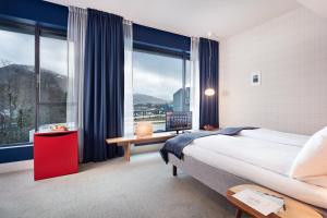 a bedroom with a large bed and a large window at Zander K Hotel in Bergen