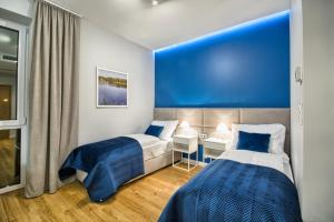 2 camas en una habitación con una pared azul en Szafir en Rogoźnik