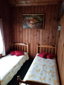 2 camas en una habitación con paredes de madera en "MARKIZAS" Karaimu 25, en Trakai