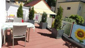 a patio with a table and chairs and potted plants at Top 2 Zi-Wohnung, 350 m zum See in Friedrichshafen