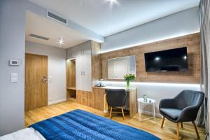 a bedroom with a bed and two chairs and a desk at Szafir in Rogoźnik