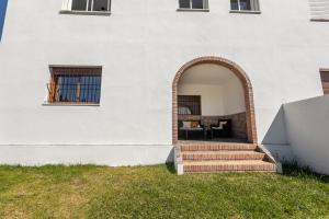 an entrance to a white building with an archway at La Casa Luz Alltarifa in Bolonia
