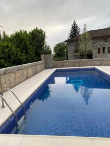 a swimming pool with blue water in front of a house at Havan House in Amarante
