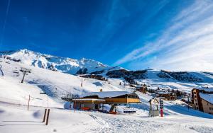 um alojamento de esqui numa pista coberta de neve com uma montanha em Parc Madeleine - CHALETS em Saint-François-Longchamp