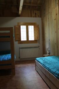 a bedroom with two bunk beds and two windows at Albergue Tejadillos in Cuenca