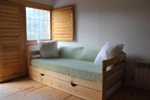 Cama en habitación con ventana en Albergue Tejadillos, en Cuenca