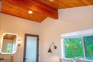 een woonkamer met een houten plafond en een raam bij Lake Level Cottages in Oroville