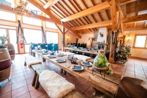 a large room with a long wooden table and benches at Parc Madeleine - APARTMENTS in Saint-François-Longchamp