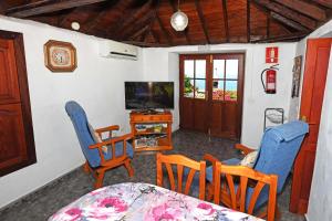 a living room with chairs and a table and a television at Casa Lorenzo in Tijarafe