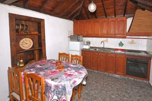a kitchen with a table and a clock on the wall at Casa Lorenzo in Tijarafe