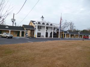 a building with an american flag in a parking lot at Mount Vernon Inn in Sumter