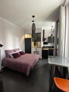 ein Schlafzimmer mit einem Bett und einem Tisch darin in der Unterkunft KRISKO parking privé et clos in Armentières