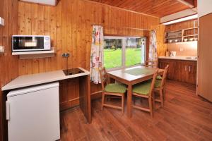 a kitchen and dining room with a table and chairs at APLEND Chaty Tatry Holiday in Veľký Slavkov