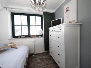 a bedroom with a white dresser and a window at de lütte Kabuff in Born