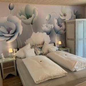 a bedroom with two beds with flowers painted on the wall at Gästehaus Kleiner Muck in Glückstadt
