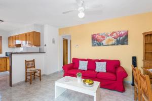 sala de estar con sofá rojo y mesa en Villas Pomelo & Papaya, en Cala en Blanes