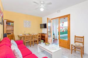 sala de estar con sofá rojo y mesa en Villas Pomelo & Papaya, en Cala en Blanes