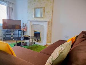 a living room with a couch and a fireplace at Airport Lounge - 3 Bed - 6 Persons in Manchester